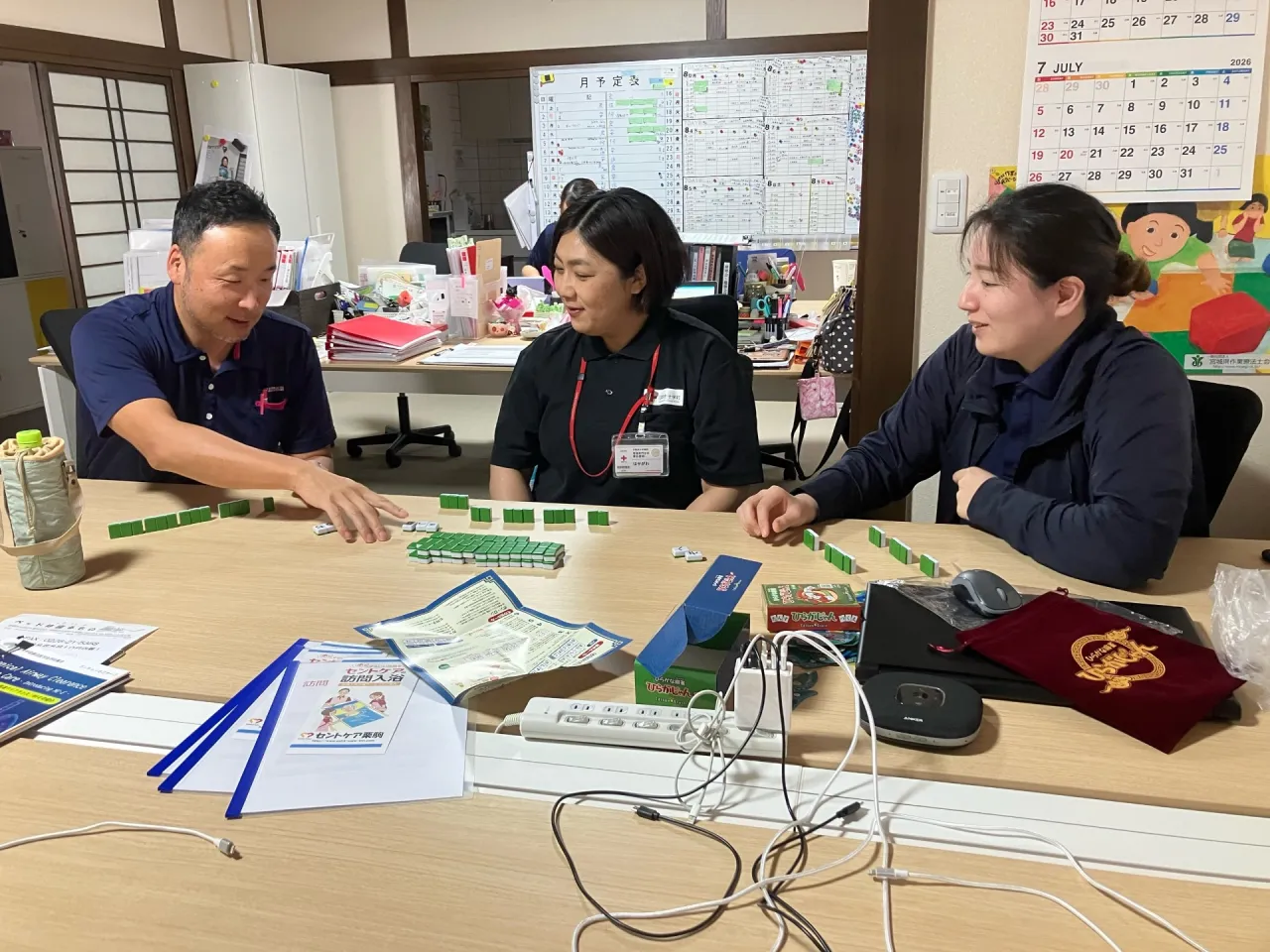 事務所でスタッフがひらがな麻雀を試している様子