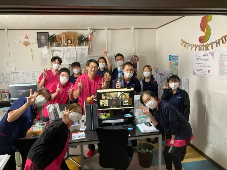 スタッフが集まって誕生日を祝っている様子